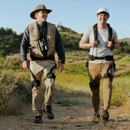 Hikers using the Hypershell exoskeleton on a trail