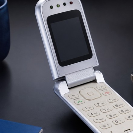 Close crop of a retro flip phone with keypad and small outer display