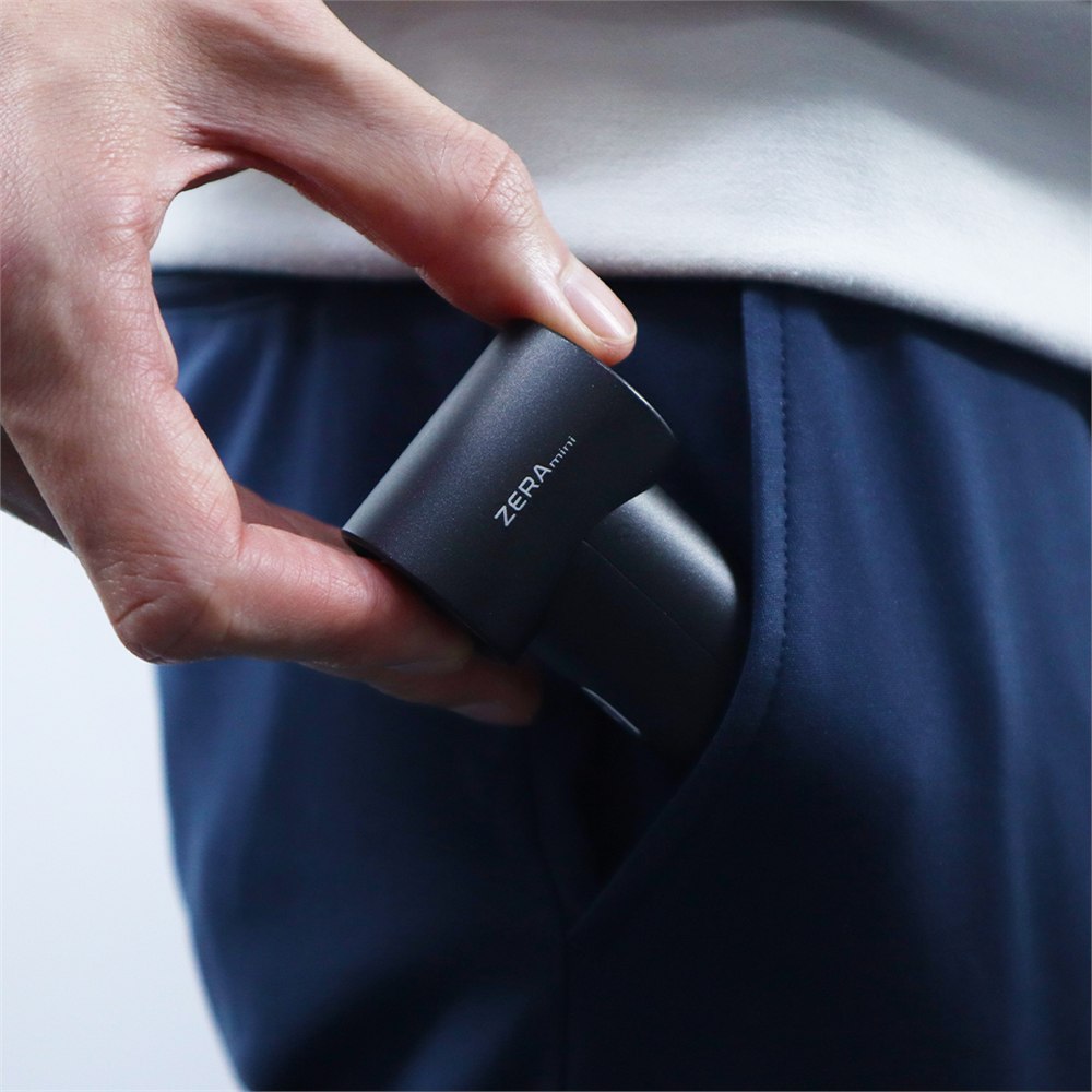 Black ZERA mini cooling fan being slipped into a pocket