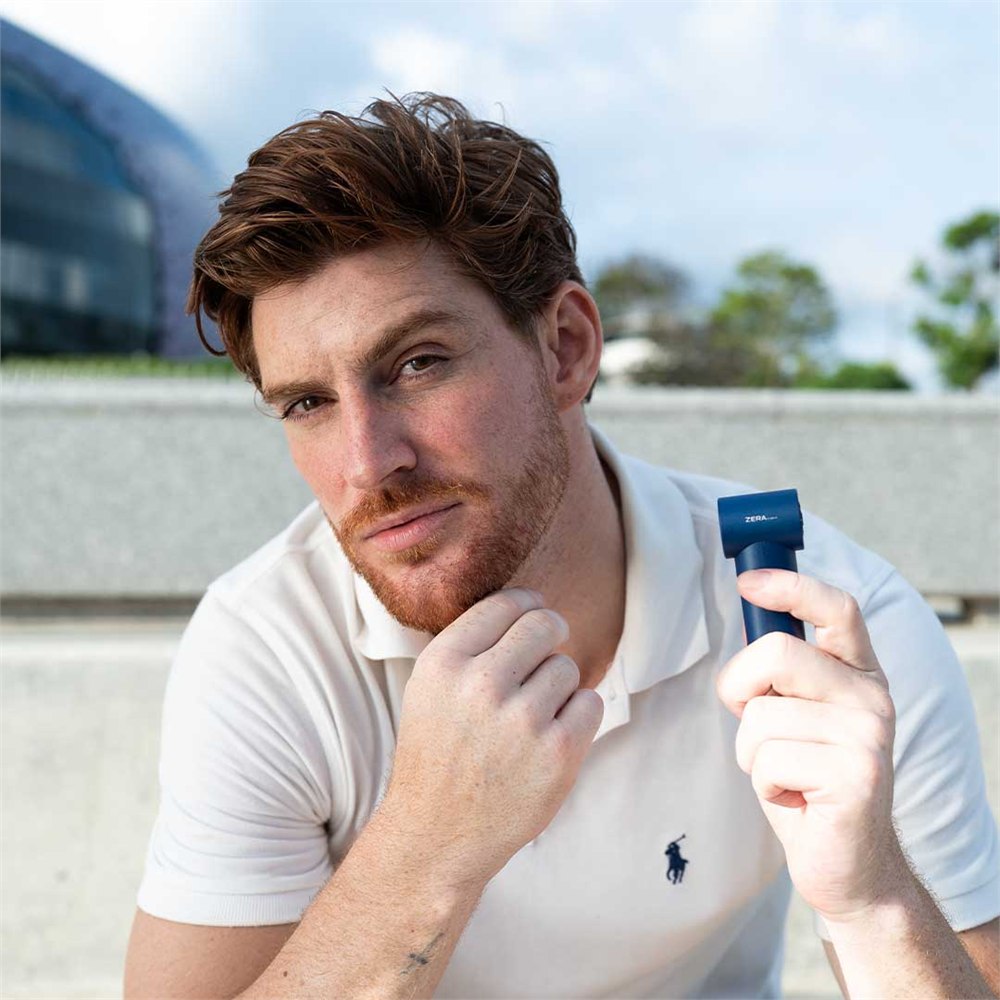 Blue ZERA mini cooling fan held in one hand