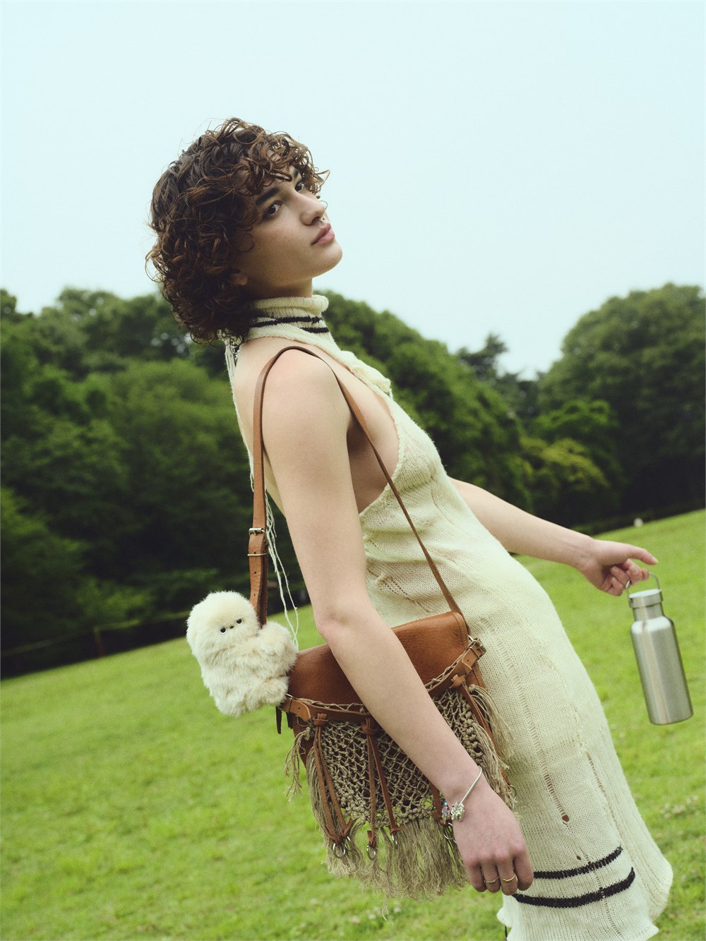 Mirumi bag-charm robot clipped to a handbag during an outdoor walk