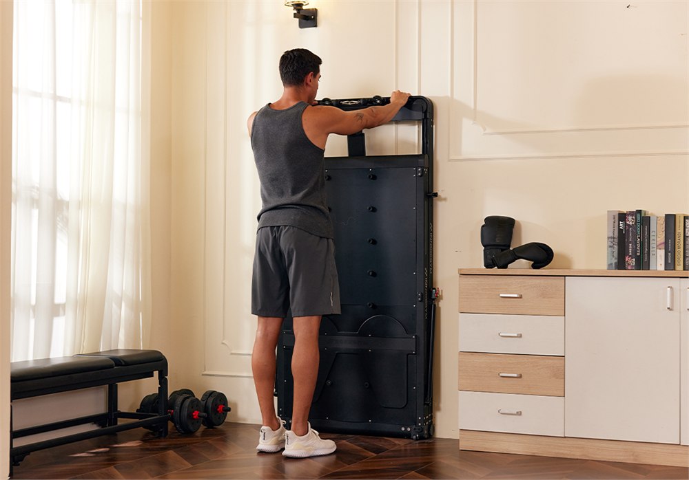 The folded OMNI X1 smart home gym stored against a wall