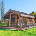 This Log Cabin Tent Has a Giant Screened In Front Porch For a True Luxury Camping Experience