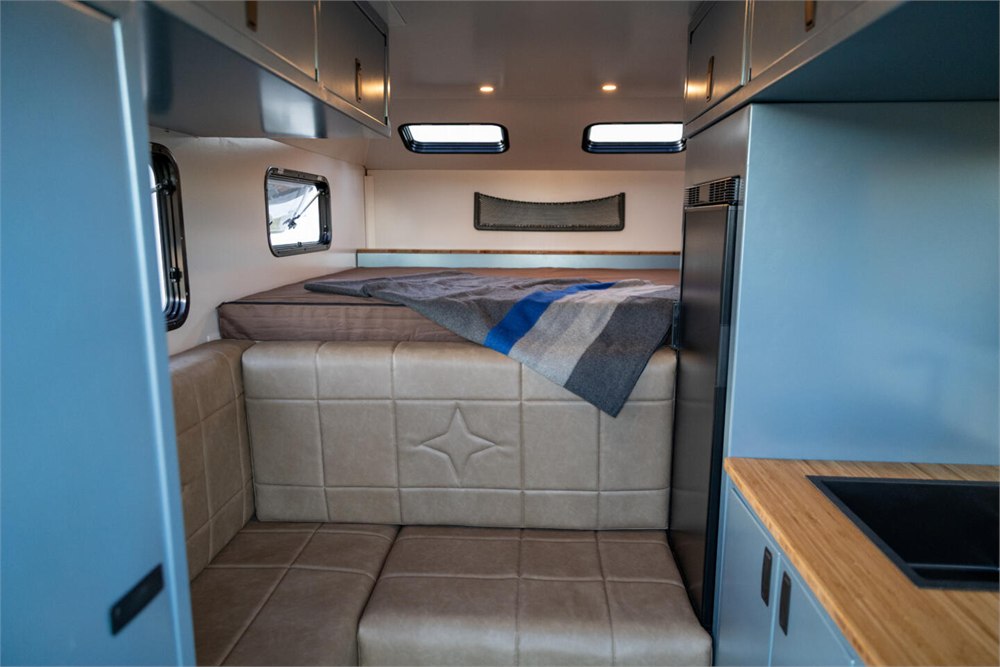 Interior bed and seating area inside the Alaskan HS 640 camper