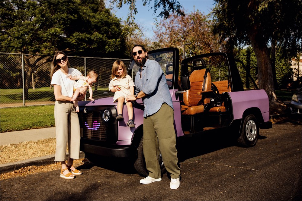 A family standing with a purple Chip Life Utility Vehicle on a neighborhood street