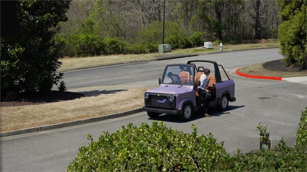 The Chip Life Utility Vehicle parked on a neighborhood road with its open cabin visible