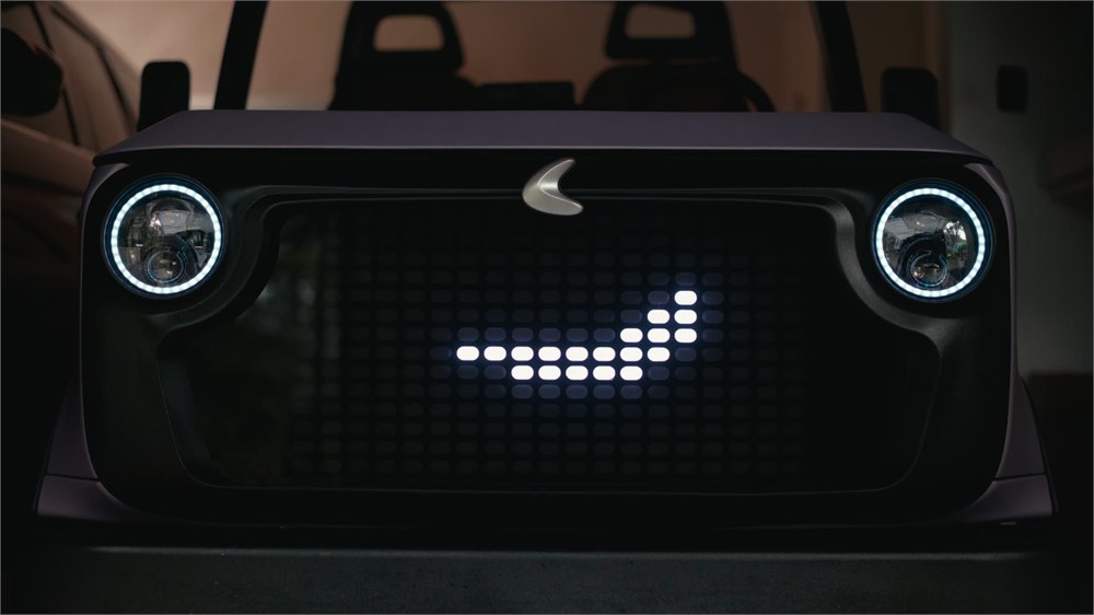 Close-up of the Chip Life Utility Vehicle front with round headlights and a dot-matrix grille face