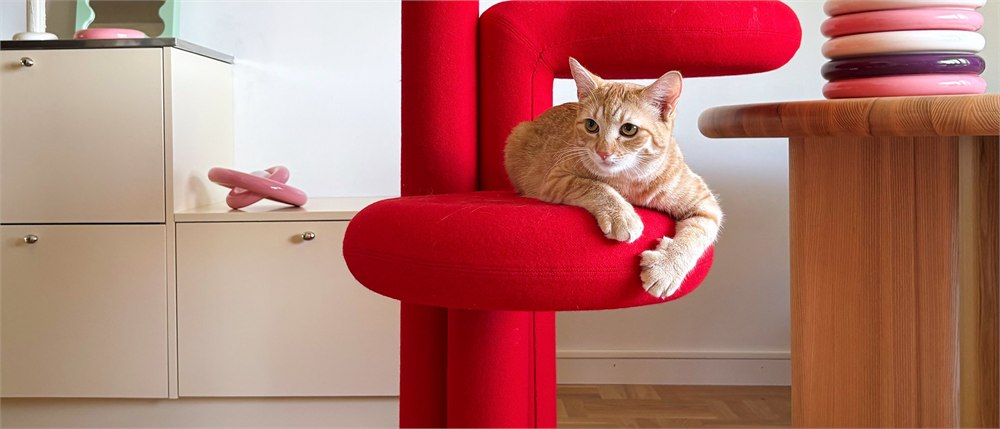 Gustaf Westman Chunky Cat Tree in red with a cat lounging on the rounded platform