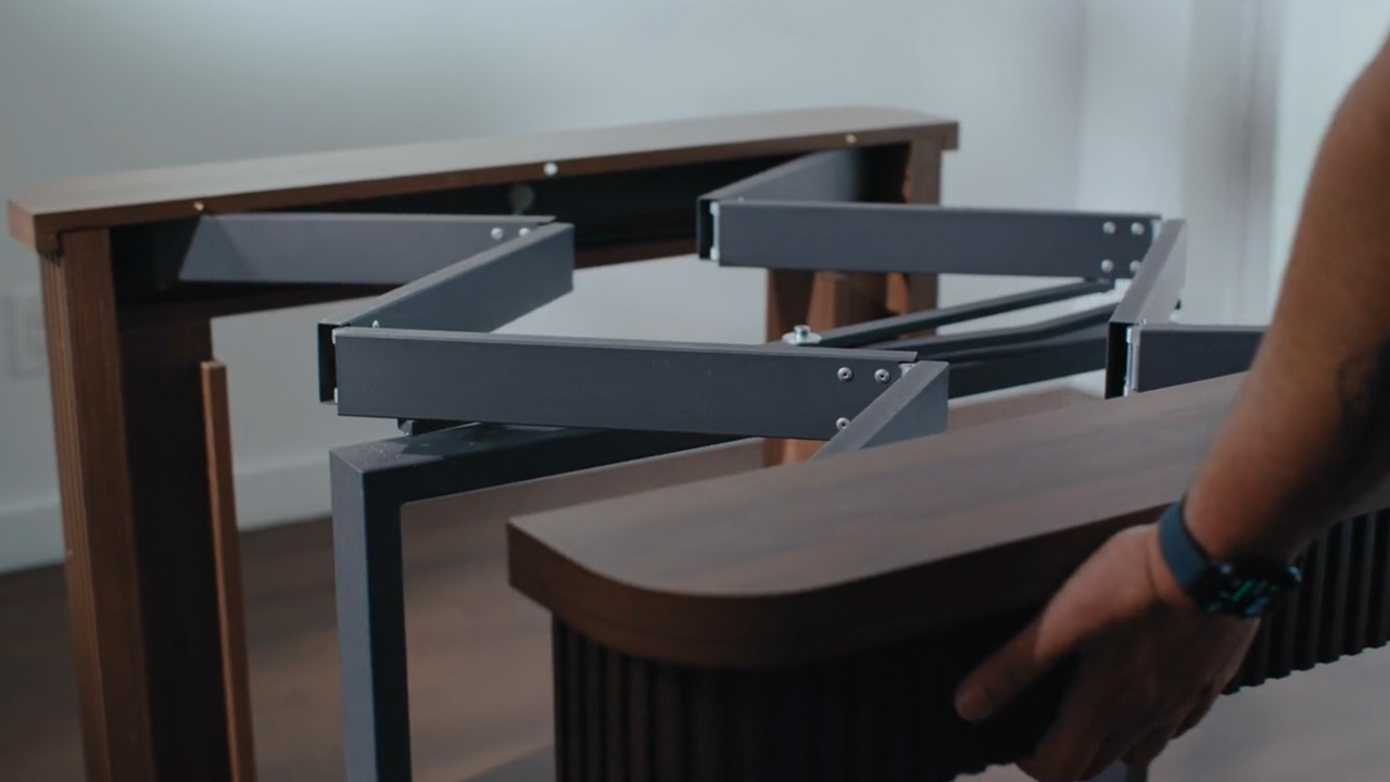 Coco Slim table showing its dark metal extension rail system