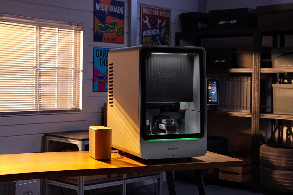 InfiMaker K1 desktop 5-axis CNC machine sitting on a workshop table