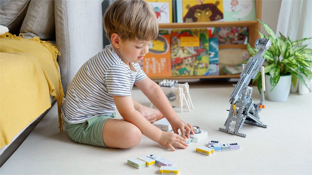Child building with CODEE magnetic coding blocks and a small robot project
