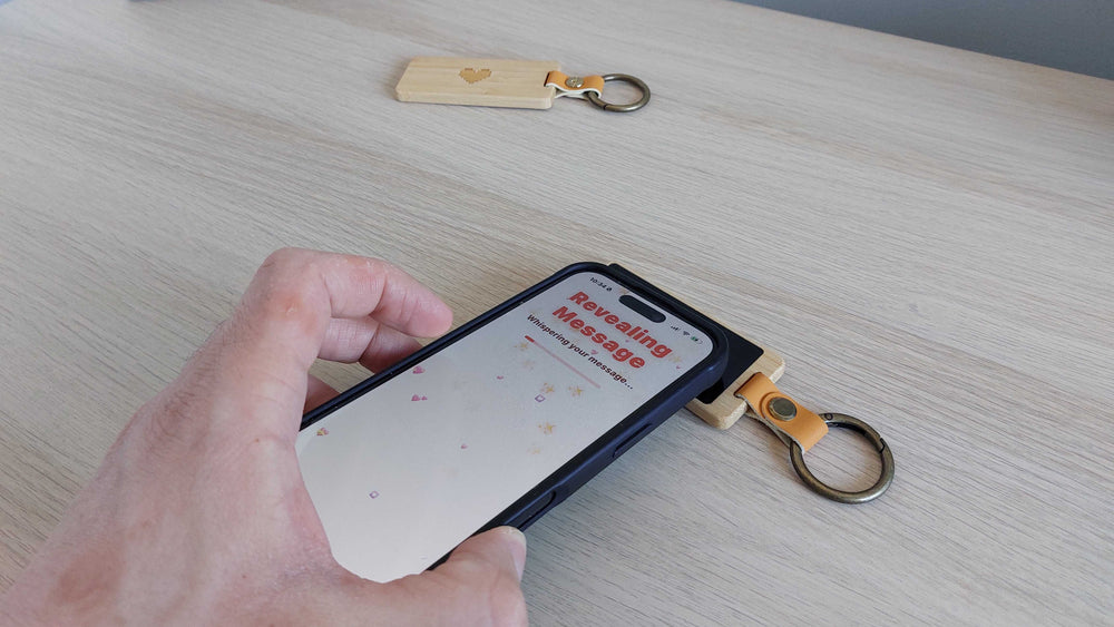 Phone tapping the KEEP e-ink keychain to reveal a note
