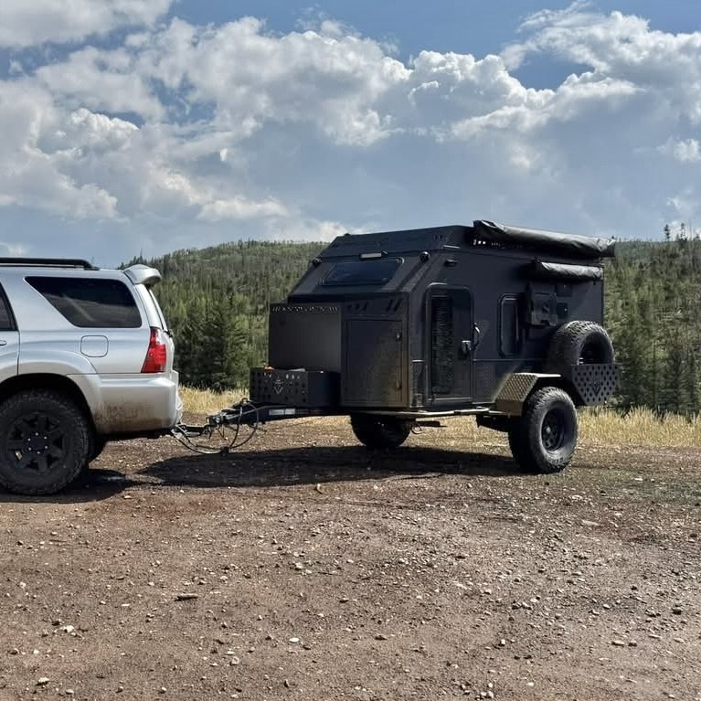 Kingdom Camping Adventure Pro Mini 2.0 off-road trailer being towed on a dirt road