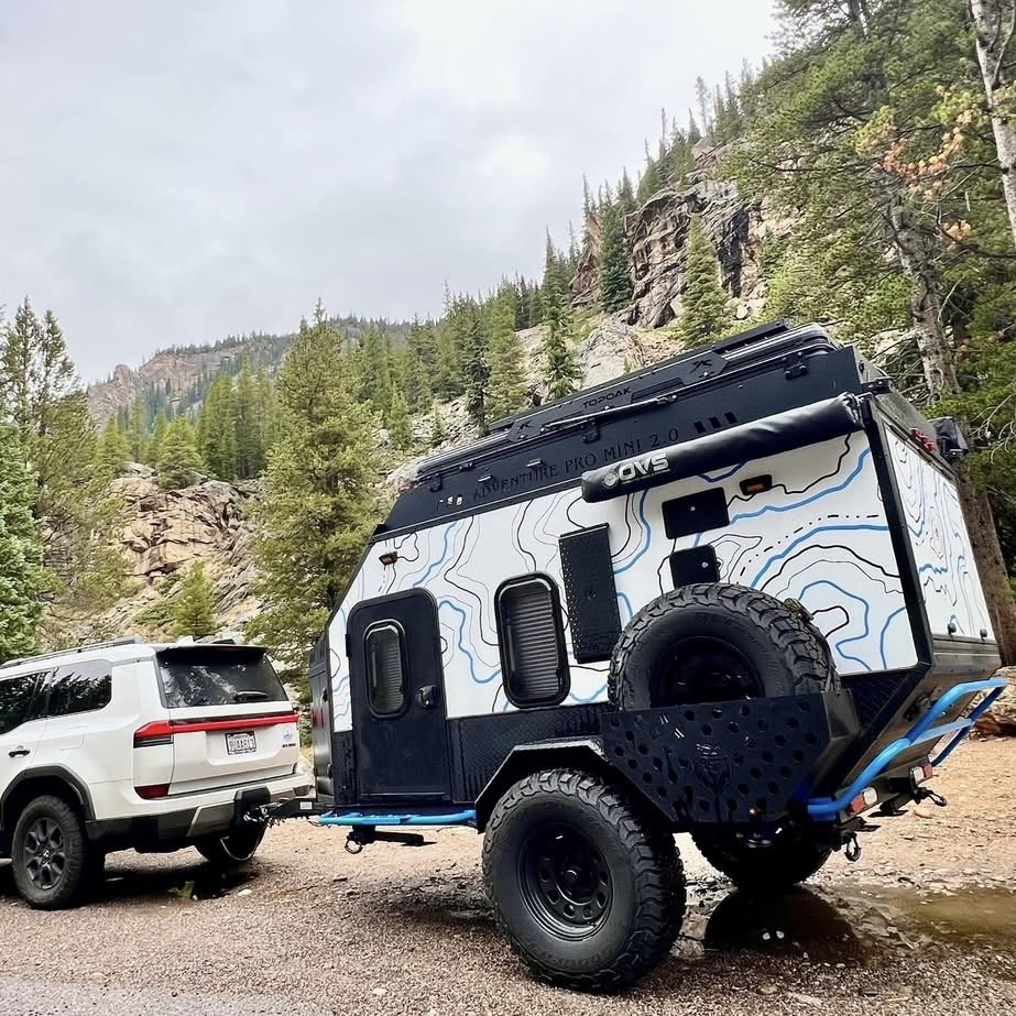Adventure Pro Mini 2.0 campsite exterior with roof rack and spare tire
