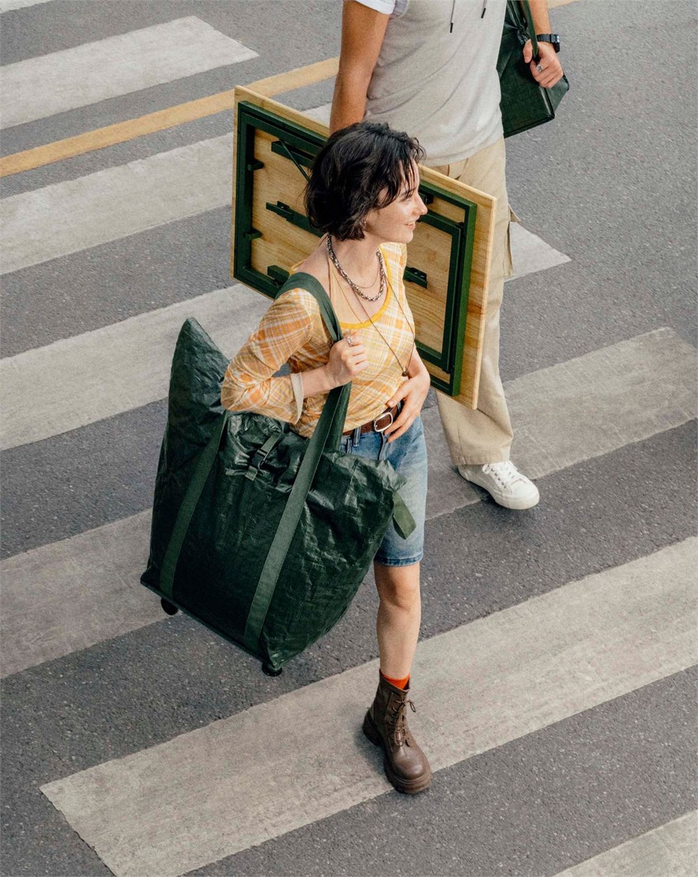IKEA KOMPISHANG rolling carry bag and portable table crossing a street.