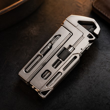 Compact titanium multitool wrench shown on a dark tabletop