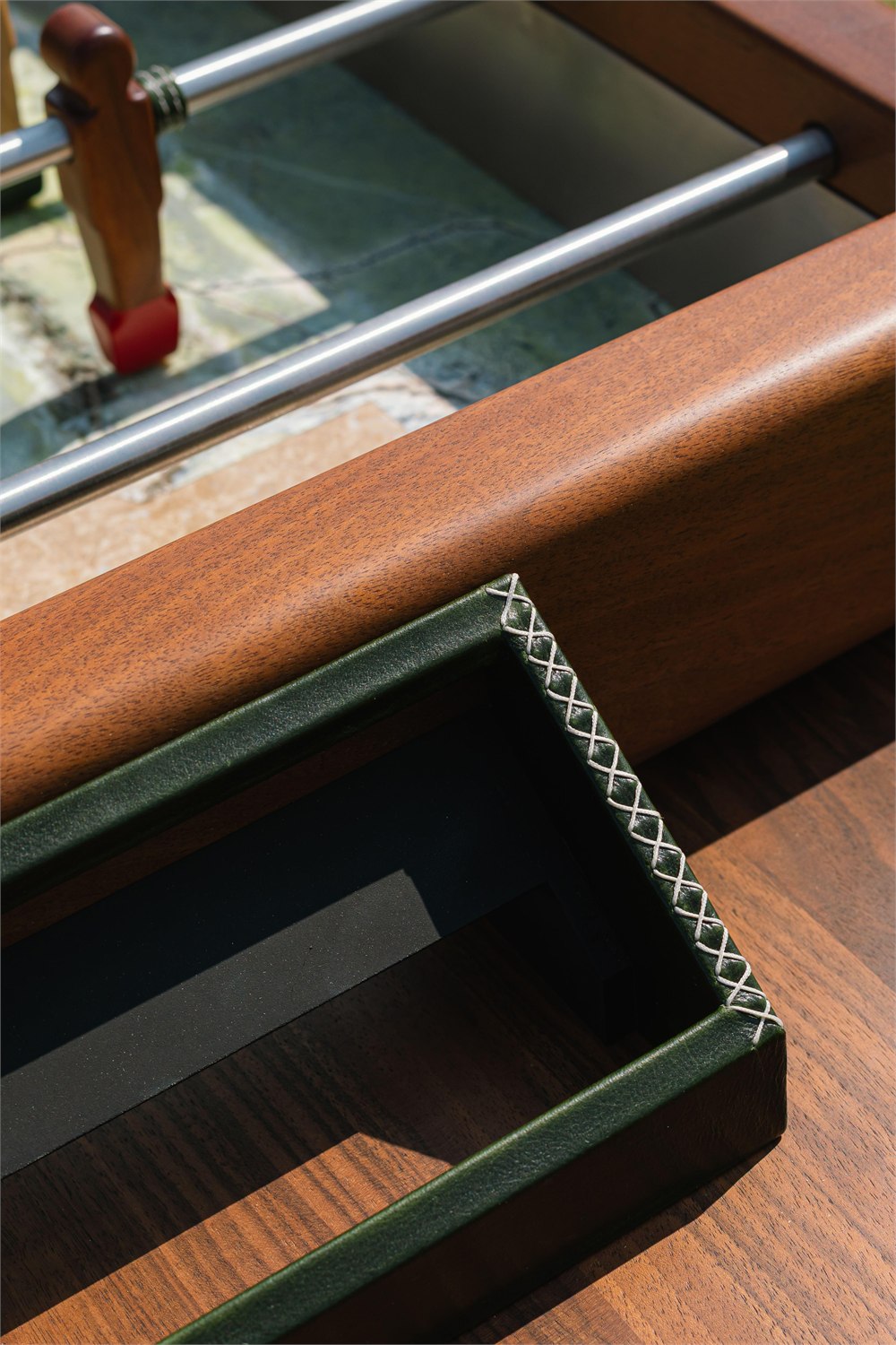 Close detail of the light wooden player and leather-wrapped goal on the Orior Foosball Table