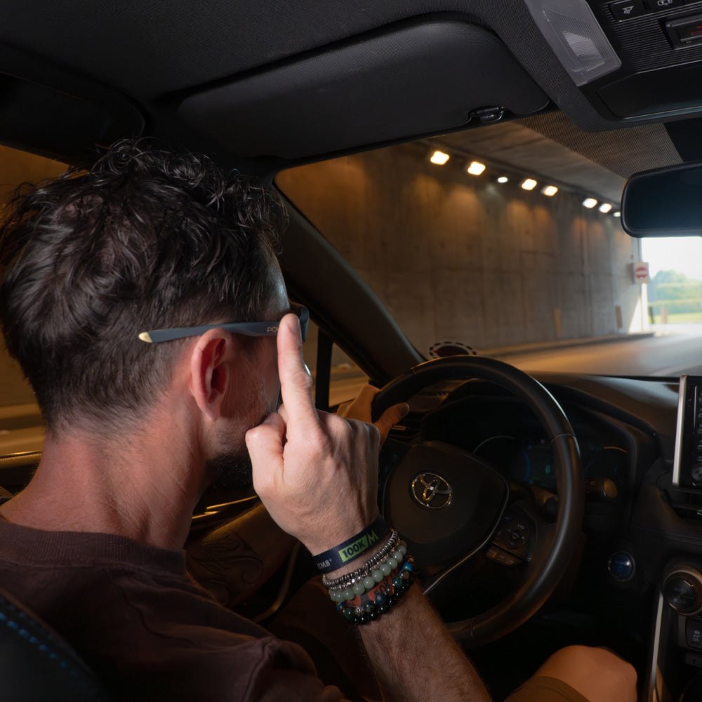 Driver adjusting POVEC C1 sunglasses while entering a tunnel