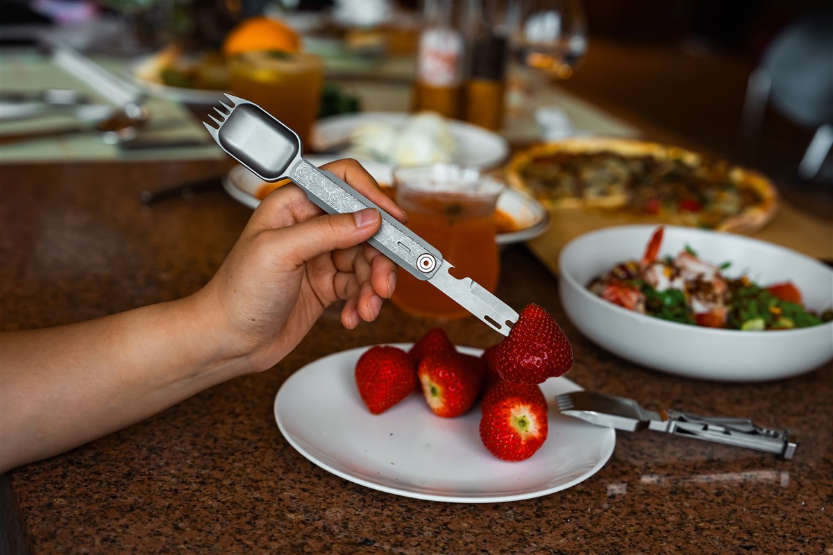 The FieldSpork with its bottle opener and fruit pick folded out beside the spork head