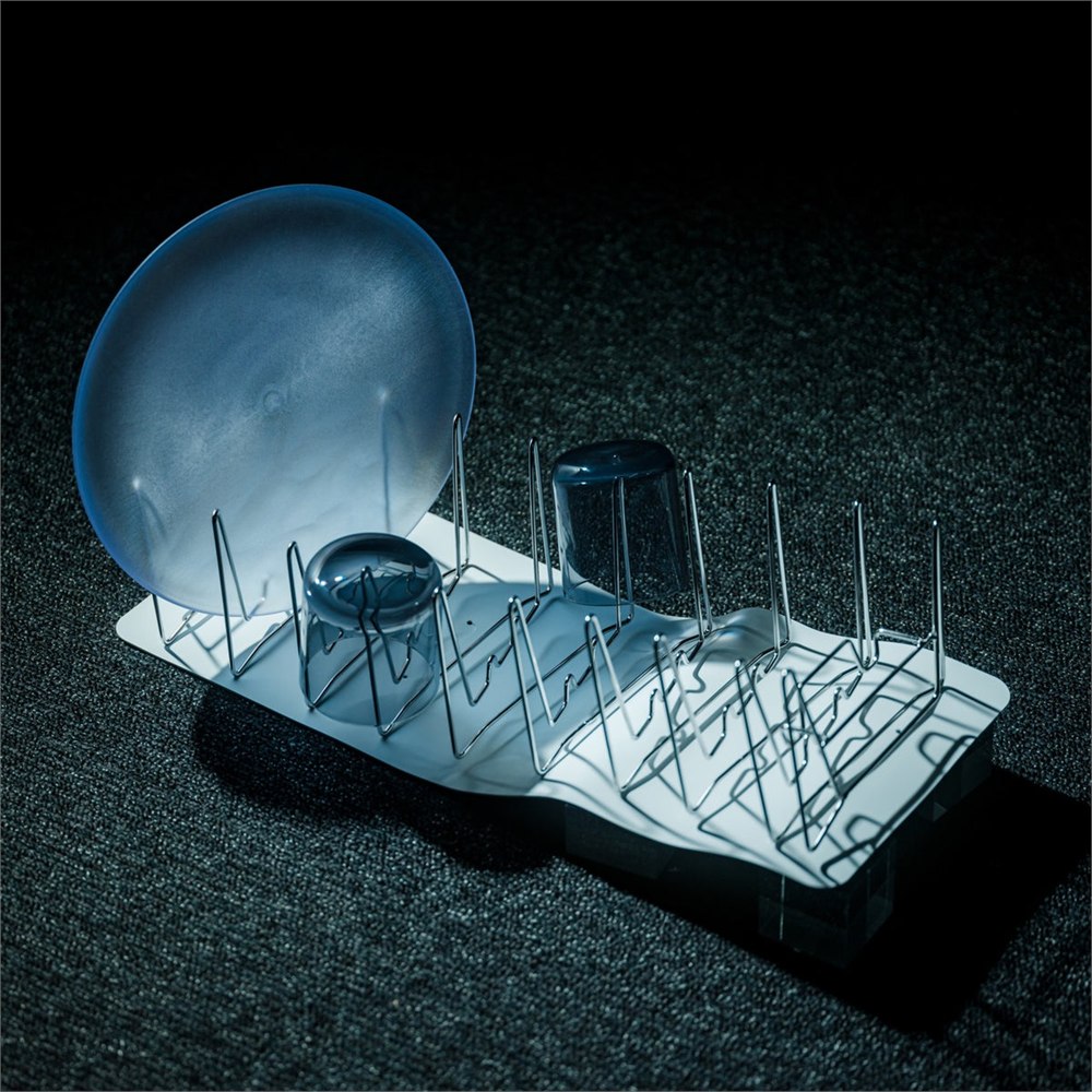 Slim Fold Dish Rack expanded on an outdoor camping table with dishes drying