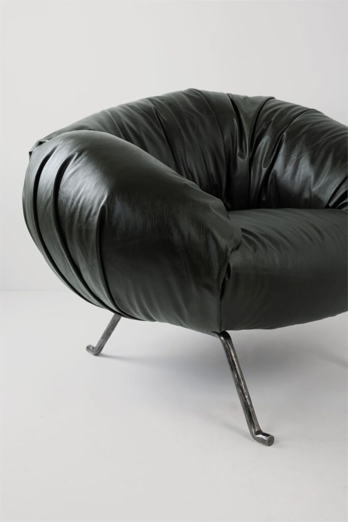 Close-up of the dark Soft Slump armchair upholstery folds and metal legs