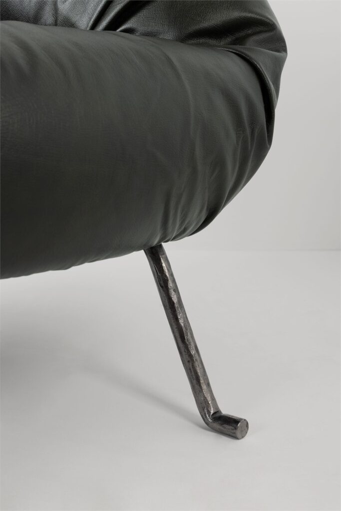 Detail view of the dark Soft Slump armchair gathered upholstery texture