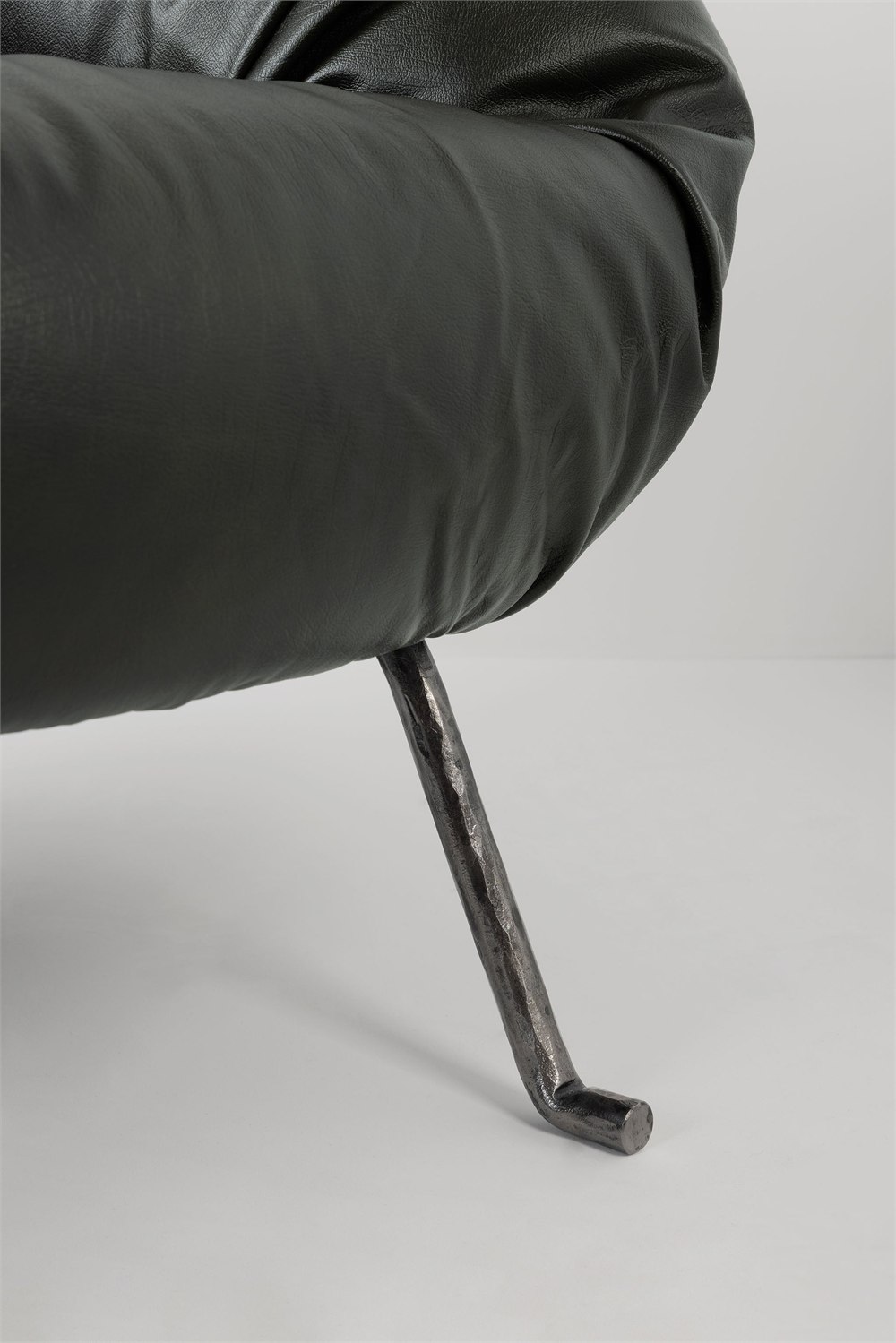 Detail view of the dark Soft Slump armchair gathered upholstery texture