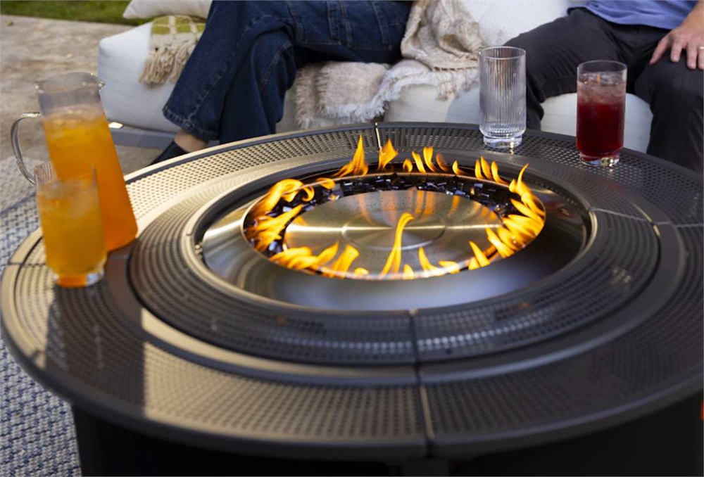 Solo Stove Infinity Flame propane fire pit table burning on an outdoor patio