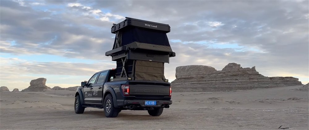 Wingman two-story pickup camper driving through desert terrain