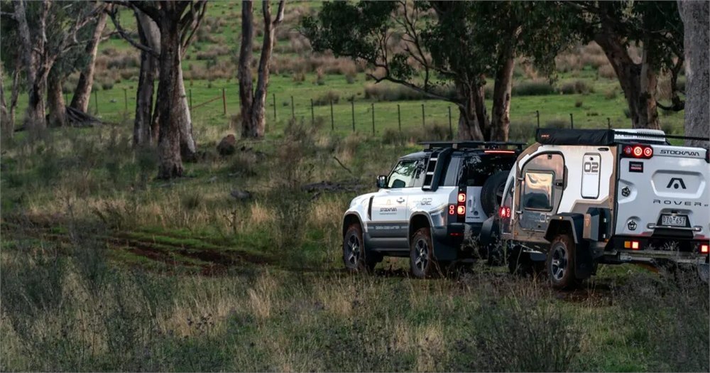 Stockman Rover camper being towed through a wooded campsite