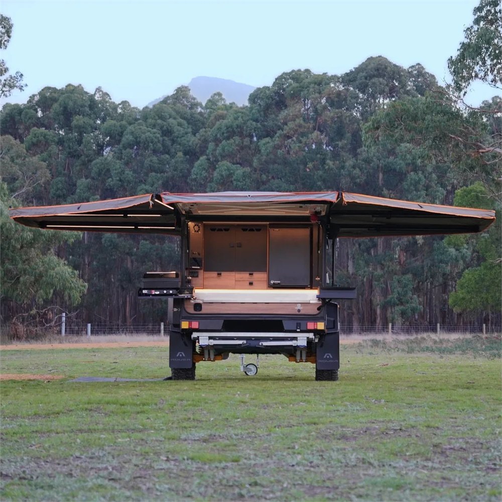 Stockman Rover camper opened with dual awnings at a campsite