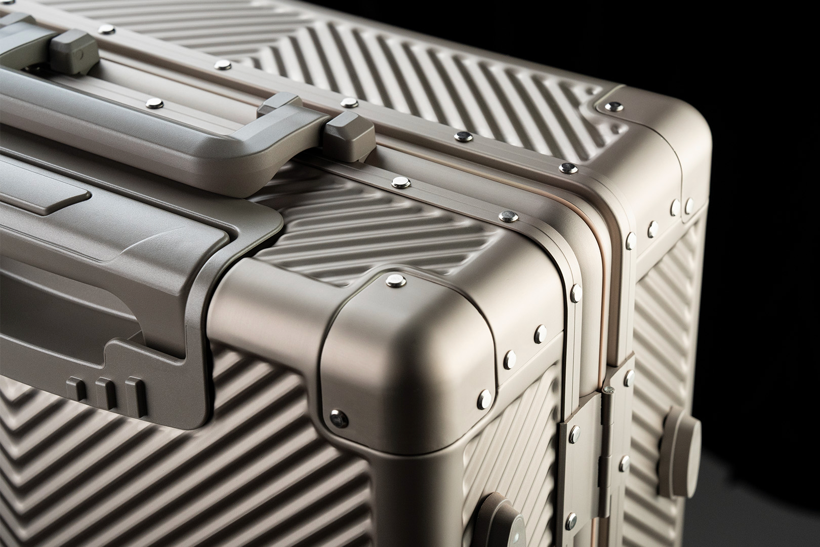 Close-up of the Titaner Voyager ribbed titanium suitcase shell and reinforced corner hardware