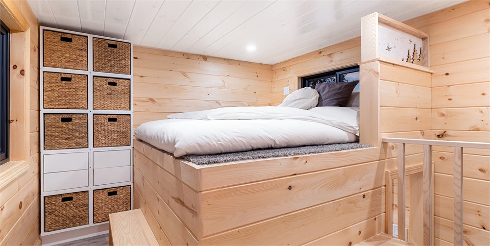 White Pine tiny house main bedroom with built in storage and wood walls