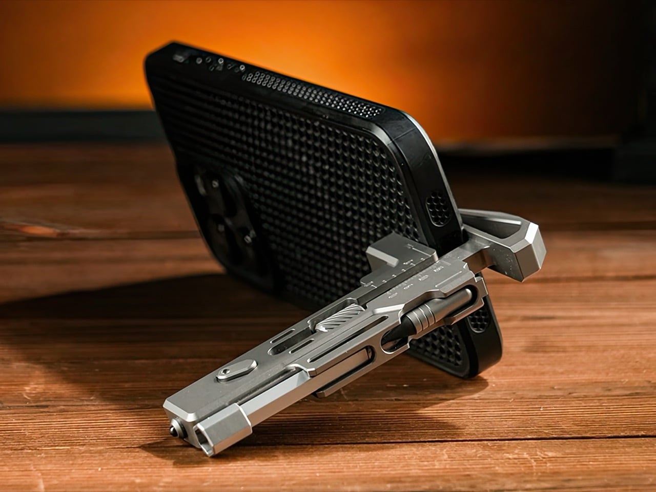 Titanium multitool wrench propping up a smartphone as a small stand