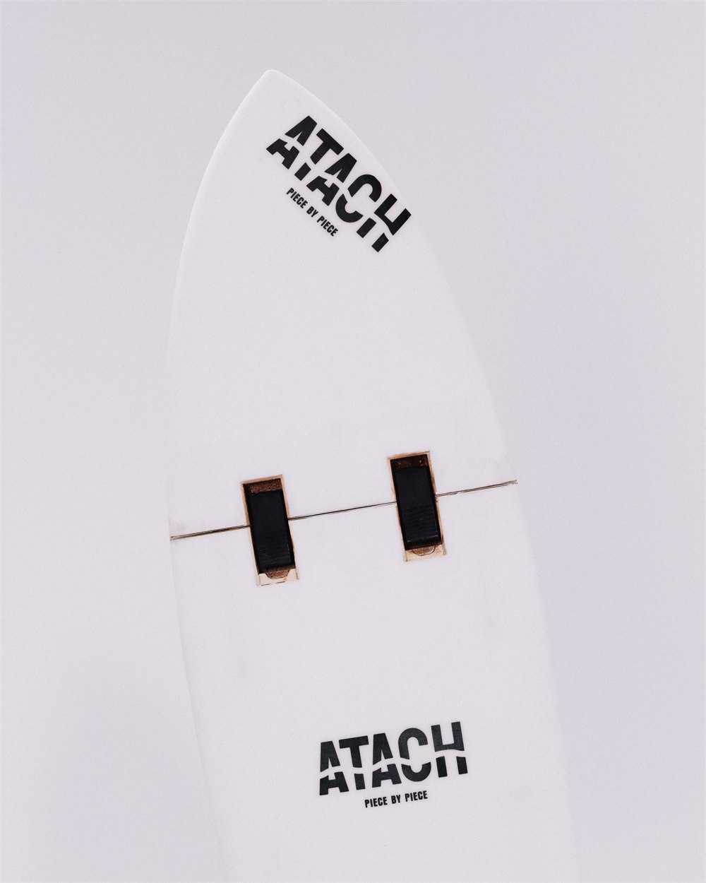 Close-up of ATACH surfboard locking system and white board surface