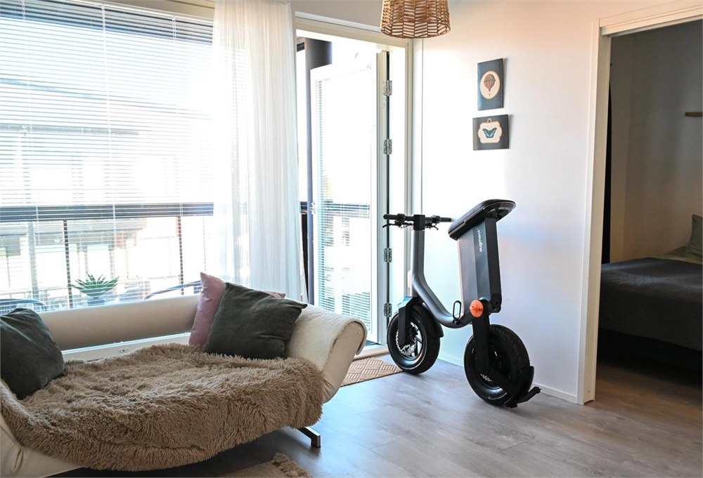Augment 360 folding electric moped parked upright inside an apartment