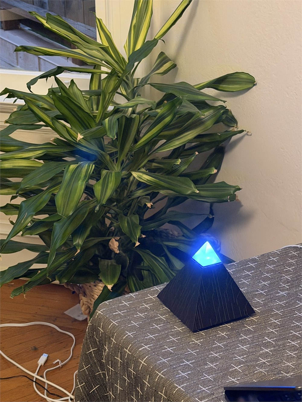 Autonomous Intern 2 glowing blue beside a houseplant