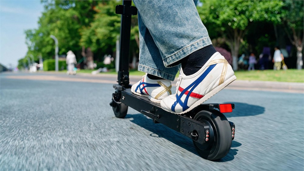 Blizwheel F0.5 electric scooter riding close-up on city pavement
