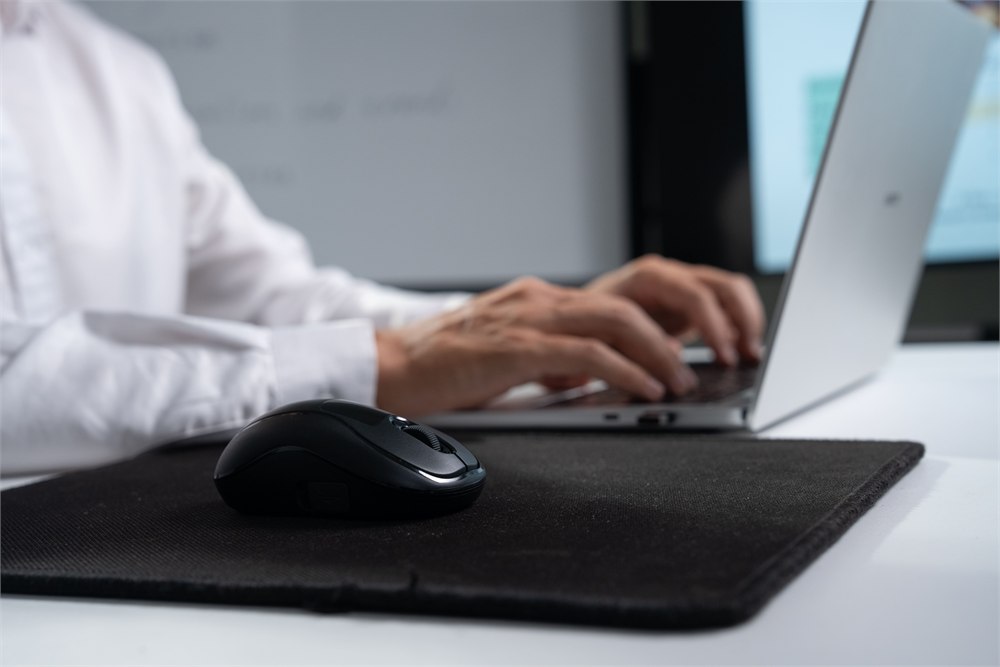 MBox DS21 ergonomic mouse docked on a desk beside a laptop