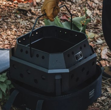 CARGO CONTAINER FIRE PIT MAX being lifted by its folding handle