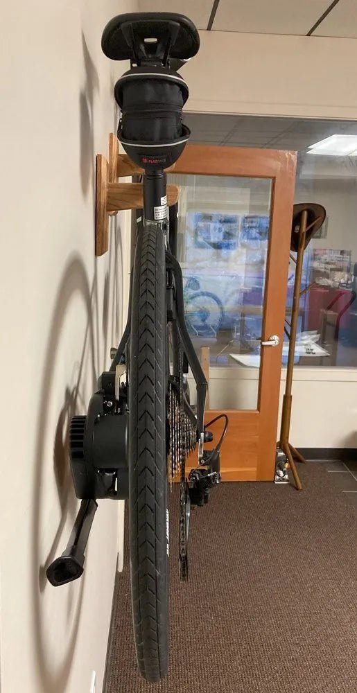 Rear view showing a bicycle's narrow profile beside a wall