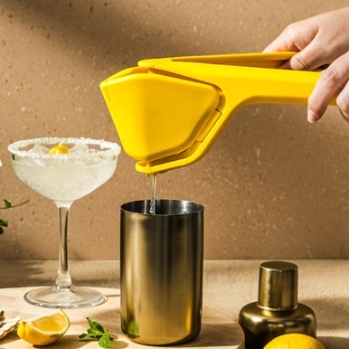 Dreamfarm Fluicer squeezing lemon juice into a glass