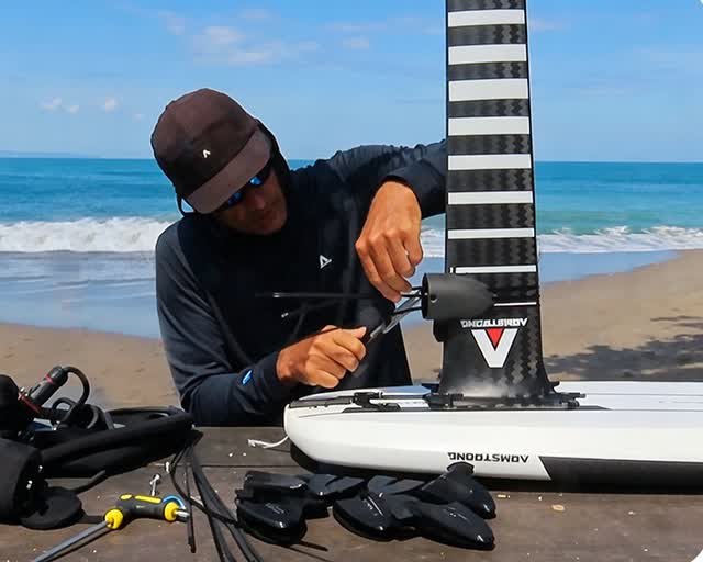 Foildash assist being installed on a hydrofoil mast at the beach