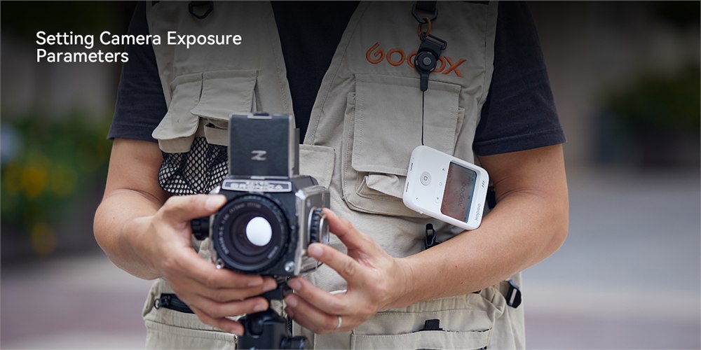 Godox C100 used as a light meter beside an analog camera