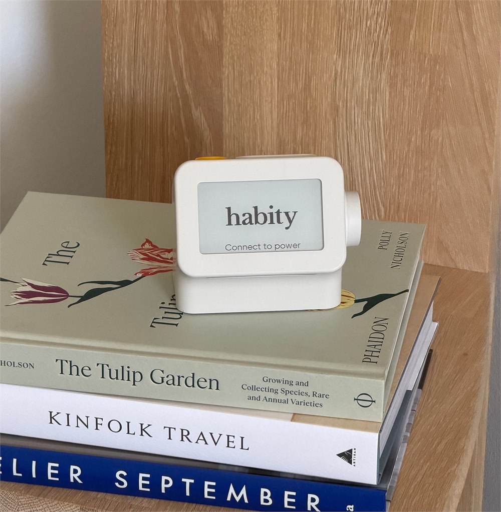 Habity bedside clock on books in a bedroom setting