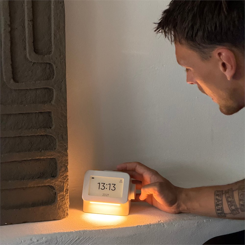 Habity bedside clock glowing while its side dial is adjusted