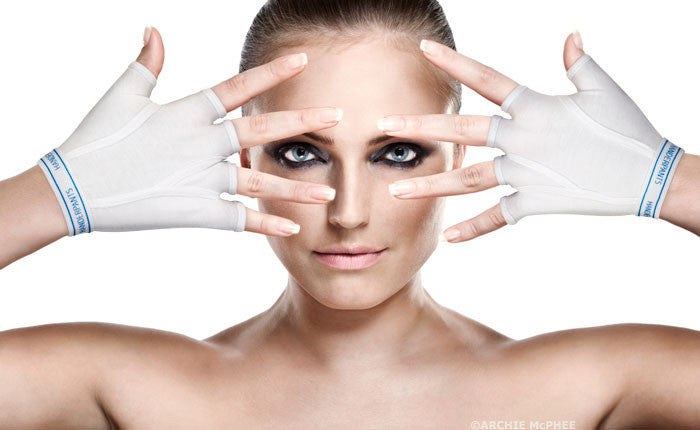 Person wearing white Handerpants fingerless gloves near their face