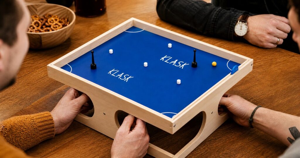 KLASK magnetic tabletop game on a table with blue playfield and wood frame