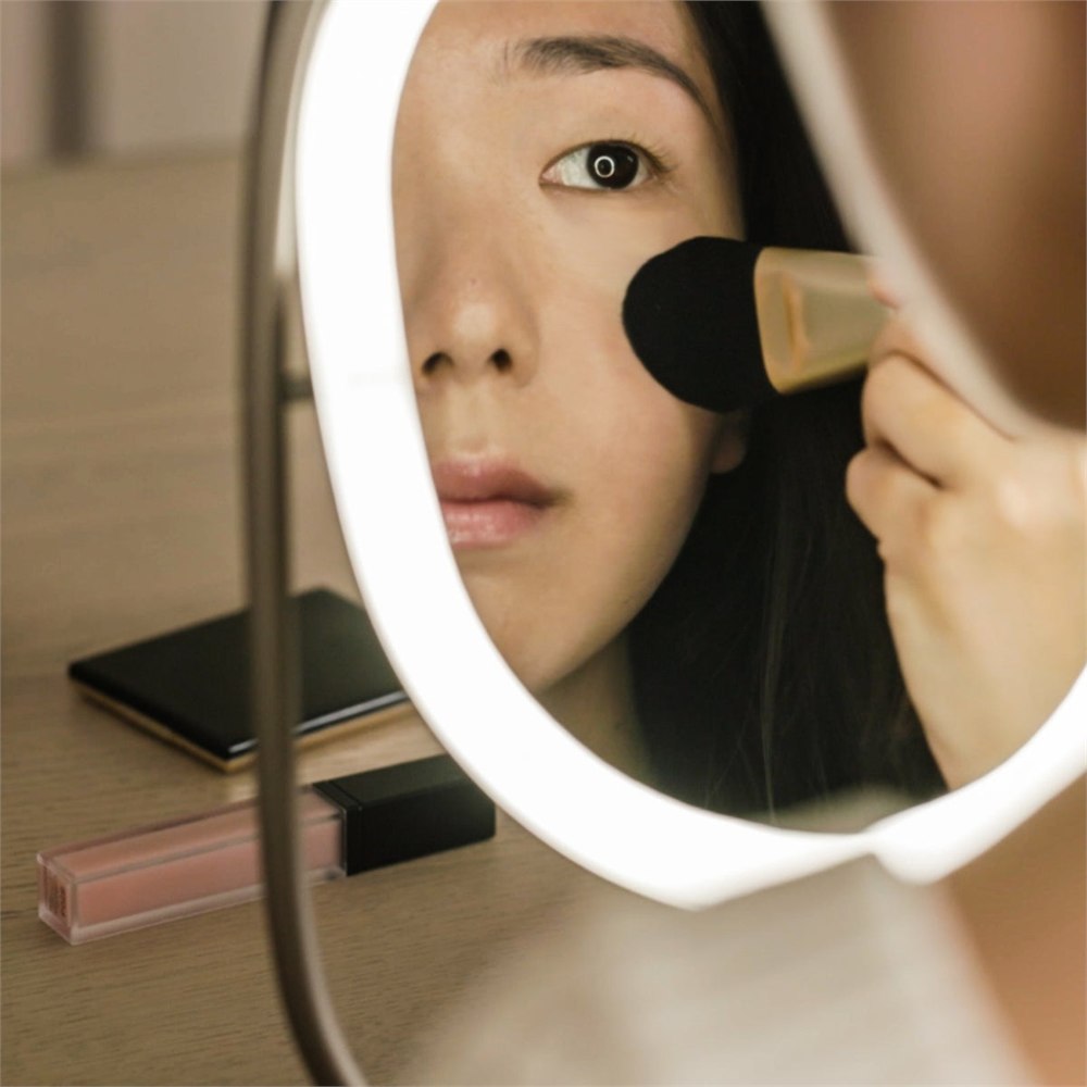 Person using the luminous mirror diffuser for makeup lighting