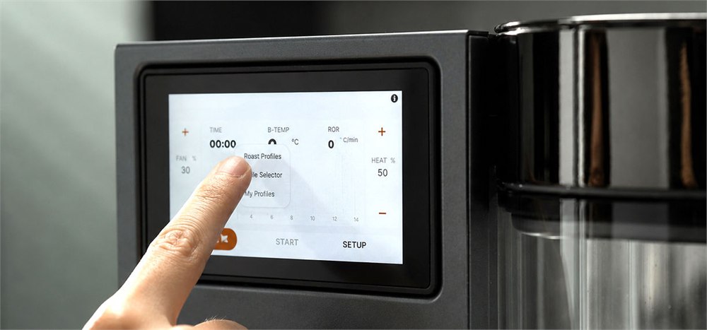Roma-X coffee roaster touchscreen controls beside the transparent roasting chamber